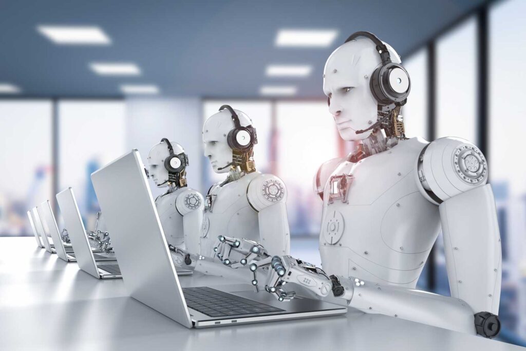 A typical bad stockphoto of AI showing three humanoid white robots sitting at tables infront of a laptop