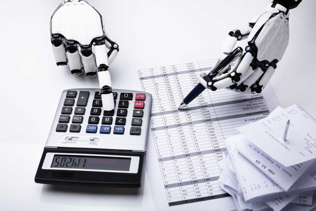 A typical bad stockphoto of AI showing two robotic hands using a calculator and a pen