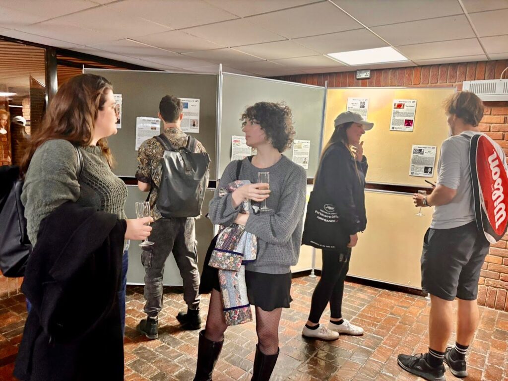 Students and artists gathered around the exhibition talking and socialising. 