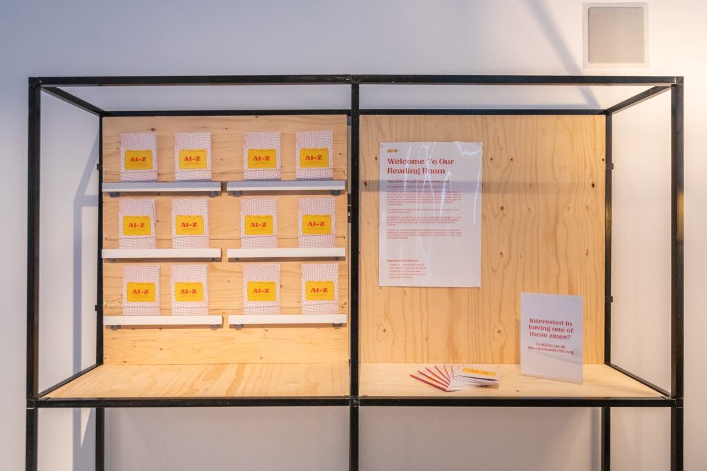 A wall with the AI-Z zines lined up and information on posters about the exhibition