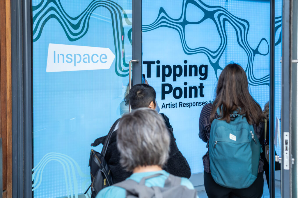 People walking into the entrance of the Tipping Point exhibition